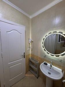 a bathroom with a sink and a mirror at Studio 102-108 in Banī Ghālib