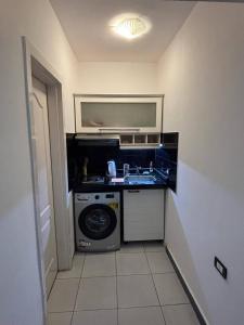 a small kitchen with a washing machine and a sink at Studio 102-108 in Banī Ghālib