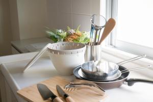 a kitchen counter with utensils on a cutting board at Maison du Voyage New-Elegant villa 3min from Kadena Air Base Gate 3 in Okinawa City