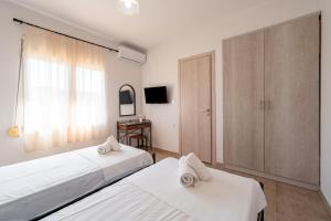 een slaapkamer met twee bedden en een televisie bij Gavriil Apartment G2 in Corfu