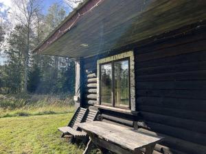 a wooden bench sitting outside of a log cabin at Pangamäe puhkemaja in Lokuta +6 photos