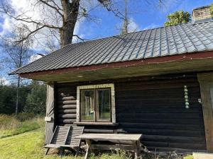 a small house with a bench outside of it at Pangamäe puhkemaja in Lokuta