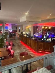 a bar in a restaurant with red lighting at Murrays in Bargoed