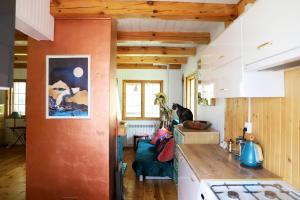 a kitchen with an orange wall in a house at Chata Wiedźmy - Sanktuarium Laparica w Puszczy Białej 