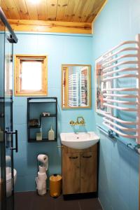 a blue bathroom with a sink and a toilet at Chata Wiedźmy - Sanktuarium Laparica w Puszczy Białej 