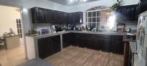 cocina con armarios negros y suelo de madera en Boquete Guest House, en Alto Boquete