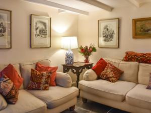 a living room with two couches and a table with a lamp at Hollyhocks Cottage in Helland +10 photos