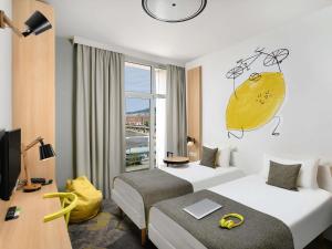 a hotel room with a bed and a large window at Ibis Styles Budapest City in Budapest +73 photos