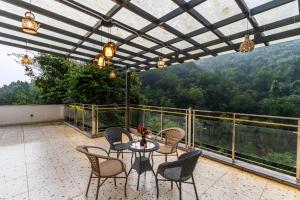 un patio avec une table et des chaises sur un balcon dans l'établissement Whishpering walls, à Jāmb