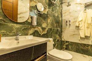 une salle de bain avec un lavabo et des toilettes dans l'établissement Whishpering walls, à Jāmb 35 autres photos