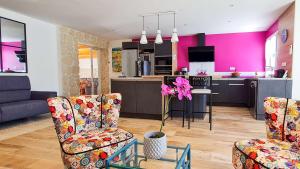 a living room with two chairs and a kitchen at Superbe villa avec piscine chauffée in Sainte-Marie-de-Ré