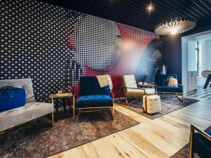 una sala de espera con tres sillas y una mesa en ibis Haguenau Strasbourg Nord, en Haguenau