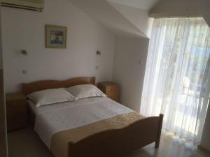 a bedroom with a bed and a large window at Guest House Pavkovic in Slano