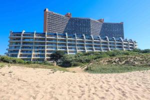 un hotel en la playa con playa de arena en L'escalier CABANAS-ON THE BEACH, en Amanzimtoti