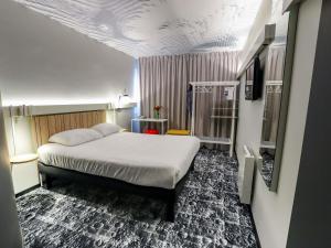 a bedroom with a bed in a room with a ceiling at ibis Haguenau Strasbourg Nord in Haguenau +129 photos
