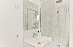 Un baño blanco con lavabo y ducha en Appartement avec balcon proche de la capitale - II, en Bagnolet 18 fotos más
