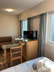 a hotel room with a bed and a table and a tv at Ao lado da Paulista e metrô lazer completo com estac in Sao Paulo