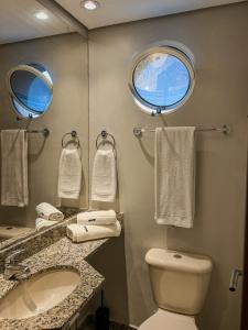 a bathroom with a toilet and a sink and a window at Ao lado da Paulista e metrô lazer completo com estac in Sao Paulo