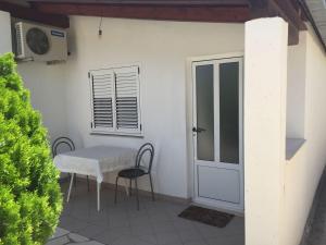 a table and chairs on a patio with a door at Guest House Pavkovic in Slano