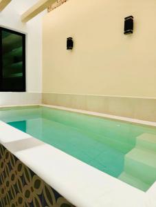 a swimming pool in a building with a swimming pool at CASA DE PLAYA con PISCINA en SISAL SÚPER EQUIPADA in Sisal