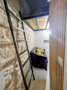 - un canapé dans une chambre dotée d'un mur en pierre dans l'établissement Superbe Studette au cœur de l'ile Saint Louis - 1 personne, à Paris