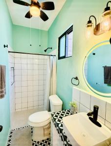 a bathroom with a toilet and a sink and a ceiling fan at CASA DE PLAYA con PISCINA en SISAL SÚPER EQUIPADA in Sisal