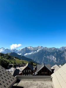 a view of the mountains from the roofs of houses at Appartement Chalet Des Lacs in L'Alpe-d'Huez