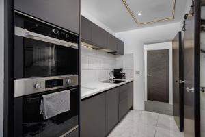 a kitchen with black and white appliances at Edinburgh City 2Bedroom & steam room! in Edinburgh +4 photos