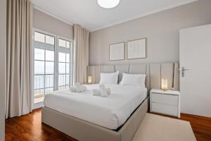 a white bedroom with a large bed and a window at Villa Eastern Edge by Homie in Caniçal +54 photos