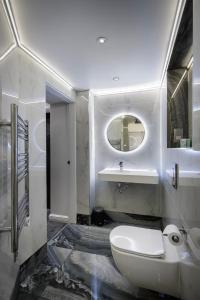 a bathroom with a toilet and a sink and a mirror at Edinburgh City 2Bedroom & steam room! in Edinburgh