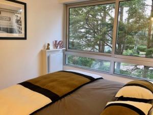 a bedroom with a bed and a large window at Les Terrasses Du Golf in Le Touquet-Paris-Plage +1 photo