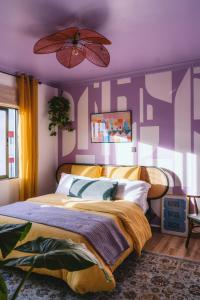 a purple bedroom with a bed and a ceiling fan at Tatu City Two Bedroom Apartment in Tatu City +22 photos