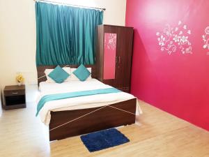 a bedroom with a bed and a pink wall at 6 CR Hotel Natraj RAILWAY STATION in Aurangabad