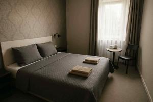 ein Schlafzimmer mit einem Bett, auf dem zwei Handtücher liegen in der Unterkunft Gryfny Hotel in Wodzisław Śląski