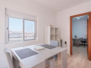 ein weißes Esszimmer mit einem Tisch und 2 Fenstern in der Unterkunft Playa, Port Fórum y BCN centro a 10 min - Apartamento con Vistas in Sant Adria de Besos