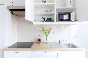 eine weiße Küche mit Spüle und einer Blumenvase in der Unterkunft Bright & Charming Apartment in Brussels, Heart of Saint-Gilles in Brüssel + 6 Fotos