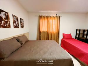 a bedroom with two beds and a window with a red pillow at Monte das cerejeiras - Bananeiras in Bananeiras