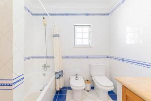 a bathroom with a toilet and a tub and a sink at Casa Margarida in Almograve +20 photos