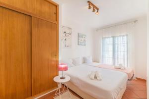 a bedroom with two beds and a red lamp at Casa Margarida in Almograve