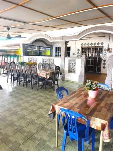 a patio with a wooden table and chairs at Kuantan SnakeRiver Homestay in Kampung Sungai Ular