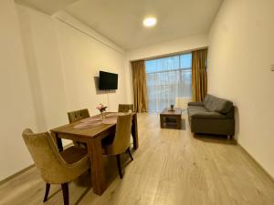a living room with a table and chairs and a couch at Kim Urban Suites in Cluj-Napoca