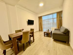 a living room with a table and a couch at Kim Urban Suites in Cluj-Napoca +4 photos