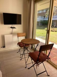 a room with a table and two chairs and a tv at Le Loft Bleu Deauville - les Petites Planches in Deauville +33 photos