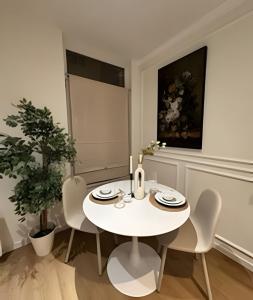 ein weißes Esszimmer mit einem weißen Tisch und Stühlen in der Unterkunft Charming Apartment in Saint-Gilles, Brussels, Perfect Getaway in Brüssel