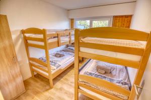 two bunk beds in a room with a window at Panorama Nid d'Aigle in Nendaz