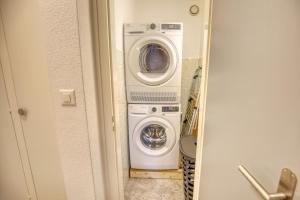 a washing machine and a washer and dryer in a bathroom at Panorama Nid d'Aigle in Nendaz