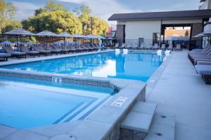 a large swimming pool with chairs and blue water at The Hotel at Black Oak Casino Resort in Tuolumne