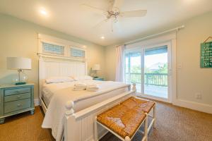 a bedroom with a bed with a ceiling fan and a window at Sea Fever in Duck +104 photos