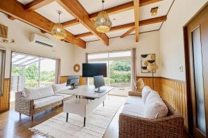 a living room with a couch and a table at Omorica Kasumigaura - ペットOK! サウナ BBQ ピザ窯完備 貸切一軒家 - 最大7名宿泊可能 in Tabuse