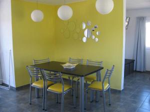 a dining room with a black table and chairs at Balcones de Los Chorrillos in Estancia Vieja